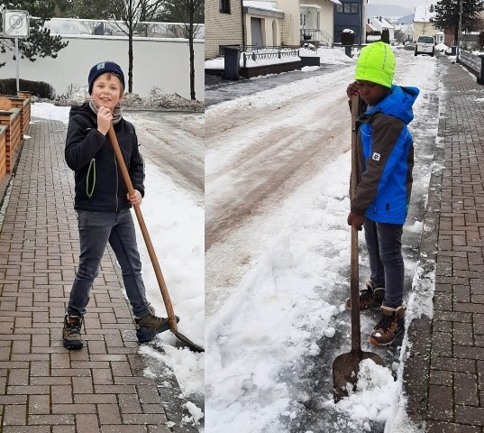 Kinderdorfkinder schippen Schnee in der NAchbarschaft